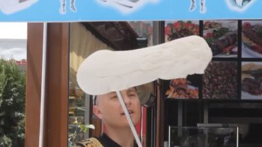 İSTANBUL, TURKEY - 23 Mayıs 2019: İstanbul 'da vanilyalı dondurma çeviren bir dondurma satıcısının yavaş çekim klibi