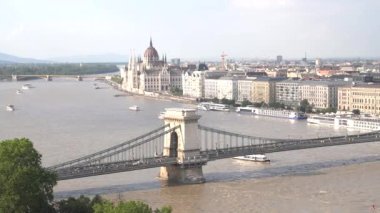 Budapeşte, Hungary 'de bir tur teknesi zincir köprünün altından geçiyor.