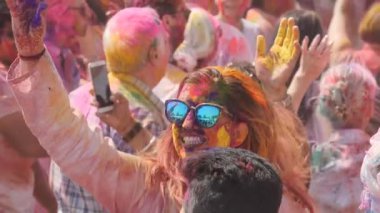 JAIPUR, INDIA - 21 Mart 2019: Jaipur, Hindistan 'da bir holi partisinde mavi gözlükle dans eden bir kızın yavaş çekim klibi