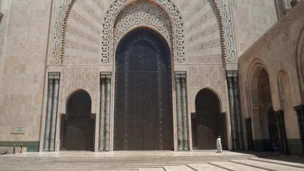 イスラム教徒の男性がモロッコのカサブランカにあるハサン2世モスクのドアを通り過ぎ — ストック動画