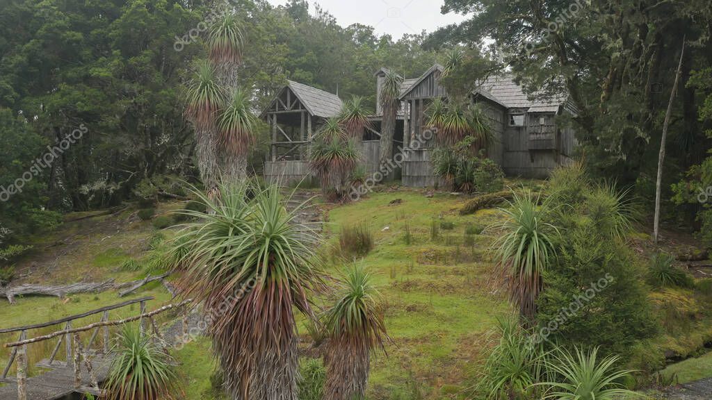 exterior of a reconstructed historic waldheim chalet and pandani plants