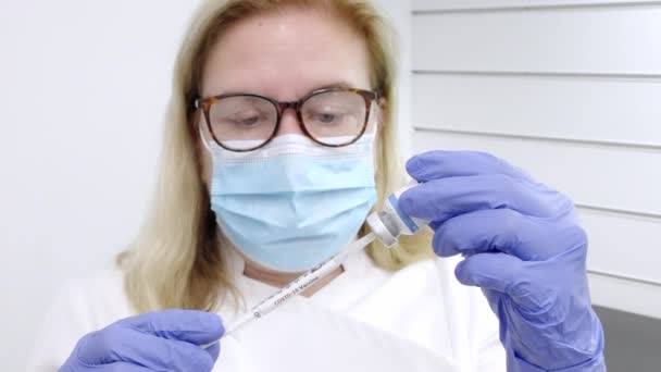 Kvinnlig Sjukvårdspersonal Fyller Spruta Med Ett Coronavirusvaccin — Stockvideo
