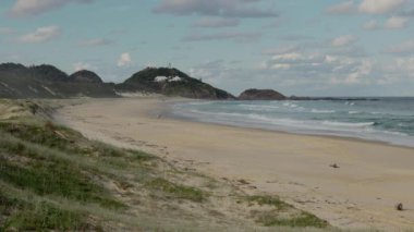 Sugarloaf Point plajı ve NSW, Avustralya 'da bir sonbahar öğleden sonrasında fok kayalıklarındaki fener manzarası