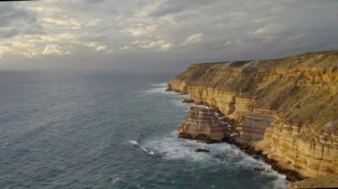 Batı Avustralya 'nın Kalbarri Ulusal Parkı' nda günbatımında geniş bir ada kayası görüntüsü.