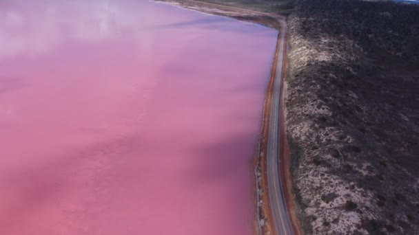 オーストラリア西部のラグーンのピンクの水の上を移動する雲の影の空中撮影 — ストック動画