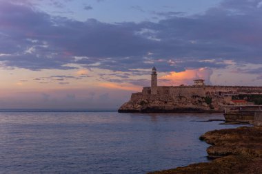 Küba, Havana 'daki Faro Castillo del Morro deniz fenerinin günbatımı çekimi.
