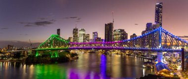 Brisbane şehrinin akşam panoramik görüntüsü. Queens, Avustralya 'daki Wilson Rezervi' nden köprü ve nehir.