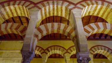 CORDOBA, SPAIN-MAYIS, 1, 2023: İspanya 'nın cami katedrali içindeki ünlü kemerlerin düşük açılı çekimi