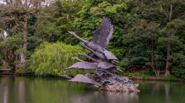 SINGAPORE, SINGAPORE- 26 Temmuz 2023: Singapur botanik bahçelerinde kuğu gölünde uçan kuğu heykelinin yan görüntüsü