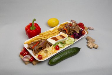 Beyaz arka planda humus, falafel ve sebze tabağı.