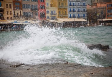 Eski kasabanın arka planına doğru deniz damlaları. Faros, deniz fenerinin önündeki bank - Chania 'daki deniz feneri.