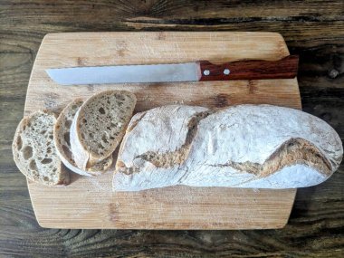 Ekmek tahtasında bıçaklı baget.