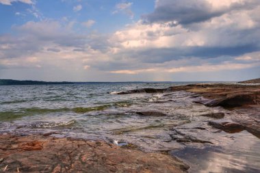 Gölün yanında kayalık bir plaj. 