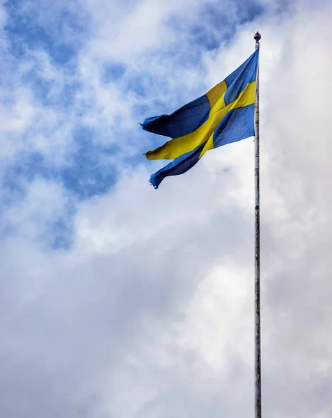 stock image a swedish flag flying on a cloudy day