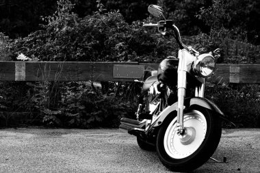 Motosiklet siyah beyaz park yerine park edilmiş. 