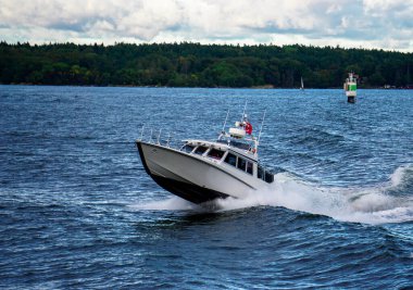 Sonbaharda Stockholm takımadalarında hızlı bir motorlu tekne.