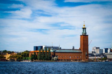 Bulutlu gökyüzüne karşı nehir kıyısındaki binaların görüntüsü