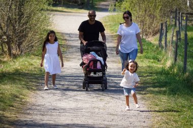 Full length of family walking on footpath amidst trees