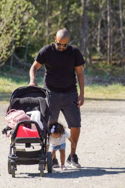 Father with stroller standing with child on a road 