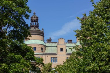 Ağaçların alçak açılı görüntüsü ve gökyüzüne karşı bina