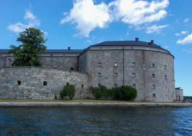 View of building by sea against cloudy sky