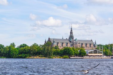 Bulutlu gökyüzüne karşı nehir kıyısındaki binaların görüntüsü