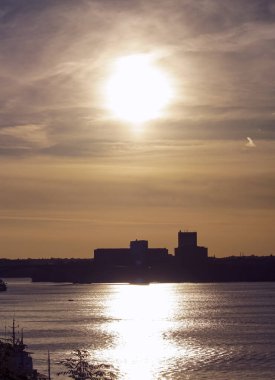 Scenic view of a river in a city against sky during sunset 