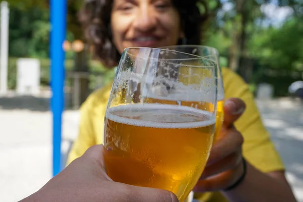 Closeup of woman toasting with beer glass
