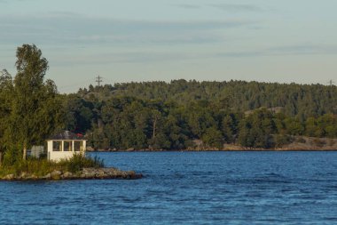 Scenic view of sea by trees against sky