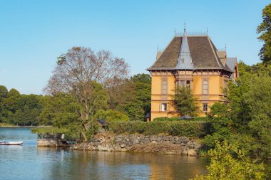 View of building by lake against clear sky