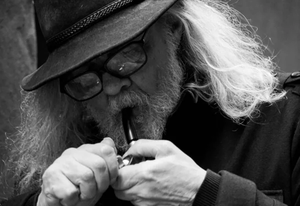 Close up of a old man smoking pipe