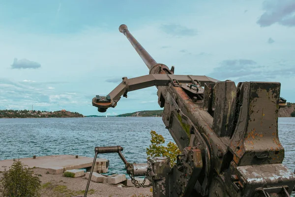Close up of abandoned cannon on island in sea against sky