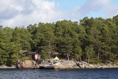 Scenic view of sea by trees against sky
