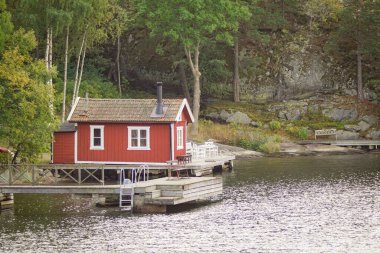 Sahilde küçük kırmızı bir bina görünüyor. 