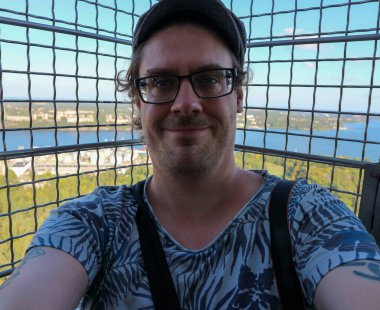 Portrait of smiling man against chainlink fence