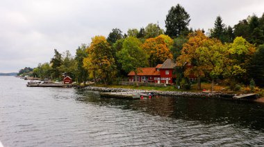 Scenic view of sea by trees and building against sky