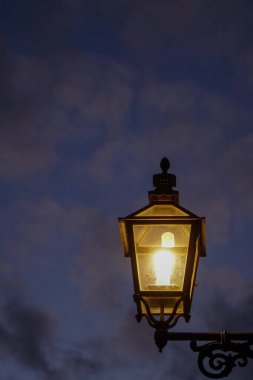 Low angle view of illuminated street light against sky at dusk