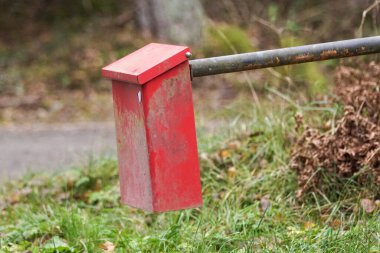 close-up of a red mailbox attached to a metal pole
