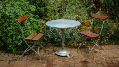 Boş sandalyeler ve arka bahçedeki masa.