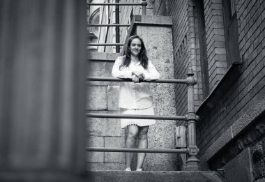 Korkulukların yanında duran bir kadının portresi