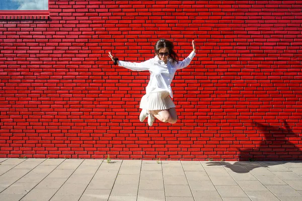 ビルの前を飛び跳ねる若い女性 — ストック写真
