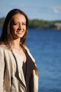 Denize karşı duran gülümseyen kadın portresi