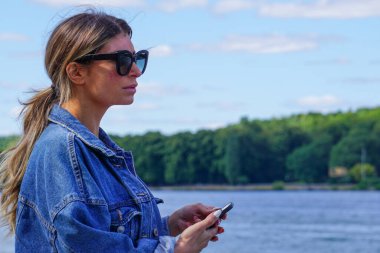 Cep telefonunu göle karşı kullanan bir kadın.