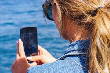 Kendi cep telefonunu çeken bir kadın.