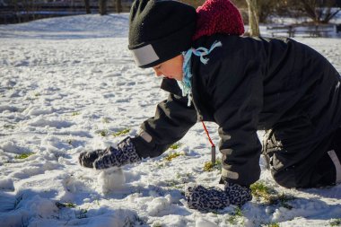Tarlada karla oynayan kızın yan görüntüsü