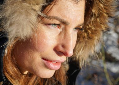 Düşünceli bir kadının bakışlarını başka yöne çevirdiği yakın plan.