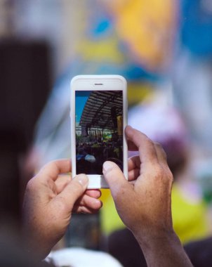 Cep telefonuyla fotoğraf çeken bir adamın elleri.