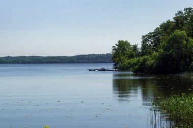 Berrak gökyüzüne karşı gölün manzarası