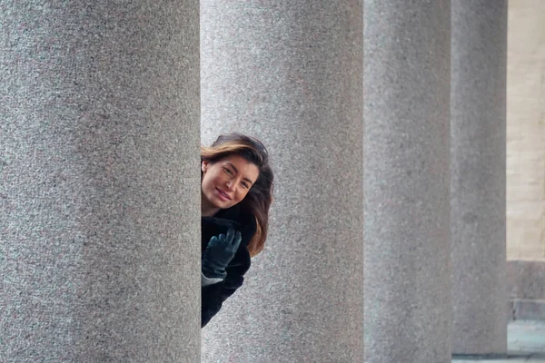 Bir Kadın Bir Binanın Sütunlarının Yanında Durur — Stok fotoğraf