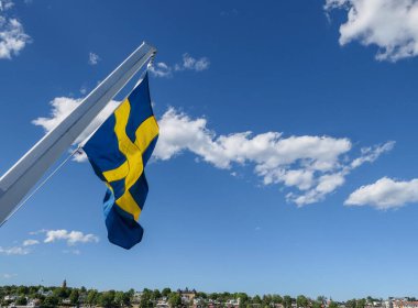Low angle view of flag against blue sky